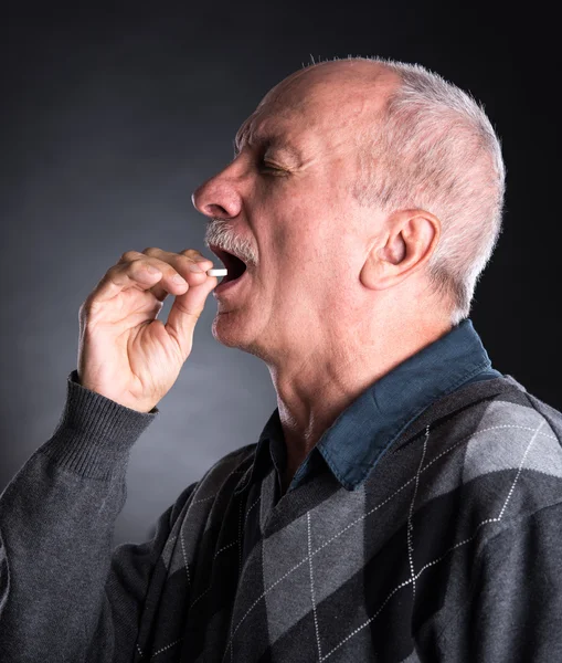 Elderly man wants to take a pill Stock Photo