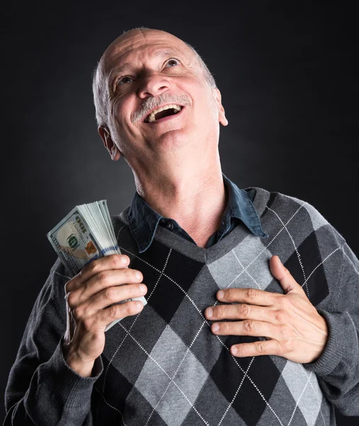 Щасливий літній чоловік показує долари Ліцензійні Стокові Фото