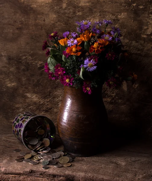 Flowers in vase and pile of old coins — Stock Photo, Image