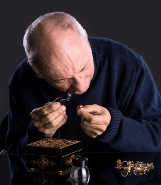 Senior jeweler  looking at jewelry clipart