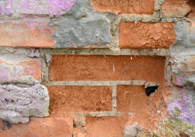 Duvarın bir kısmı aşınmış ve yıpranmış tuğlaları gösteriyor. Havan topunun bir kısmı kayıp ve kenarlarında soluk boya var.