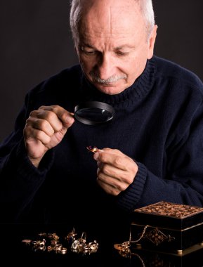 Senior jeweler looking at jewelry clipart