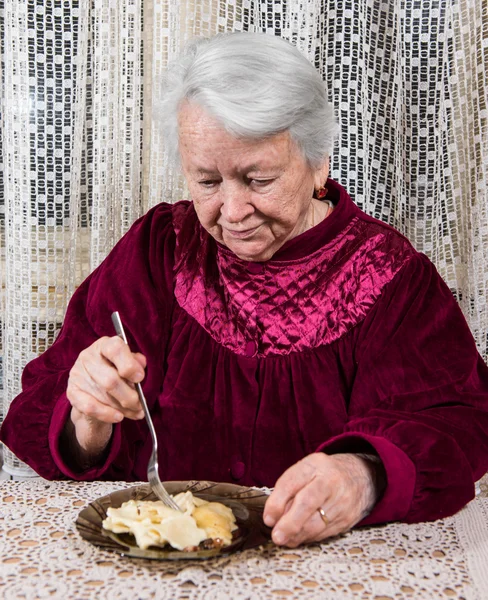 Yaşlı kadın evde yemek — Stok fotoğraf