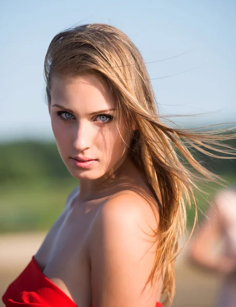 Güzel bir genç kadın kırmızı kumaş — Stok fotoğraf