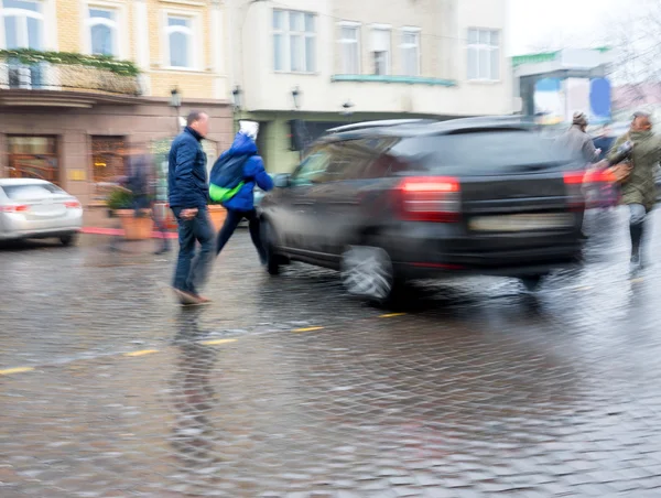 Dangerous city traffic situation with pedestrian and car — Stock Photo, Image