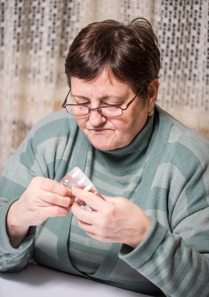 Szomorú magas rangú nő gazdaság tabletták — Stock Fotó