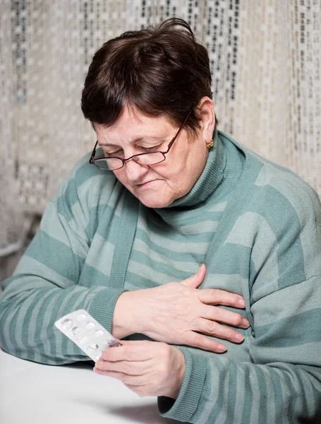 Traurige Seniorin hält Pillen in der Hand — Stockfoto