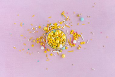 Sarı şeker pembe arka planda tanecikli, yakın planda düz uzanır.