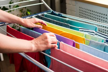 Çamaşır günü Gökkuşağı renginde giysiler çamaşır ipine asılarak evde kurutuluyor.