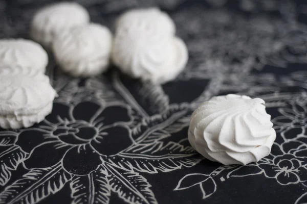 Vue du dessus des marshmallovs lettons - zefiri sur fond blanc avec nappe florale foncée — Photo