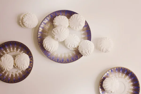 Letonca marshmallovs - zefiri beyaz arka planda, vintage filtre porselen Tabaklarda Üstten Görünüm