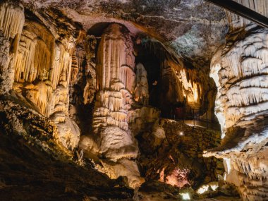 Postojna mağarası, Slovenya ve Avrupa 'daki dev sarkıtlar, dikitler ve dikdörtgenlerle büyük mağaralardaki turistler için harika bir geçiş resmi..