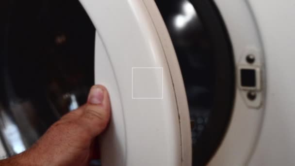 Omul deschide ușa mașinii de spălat, focalizarea selectată pe ușă — Videoclip de stoc