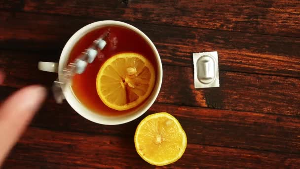Muž hází pilulky do šálku čaje s citronem. Podzimní nachlazení, nemoc — Stock video