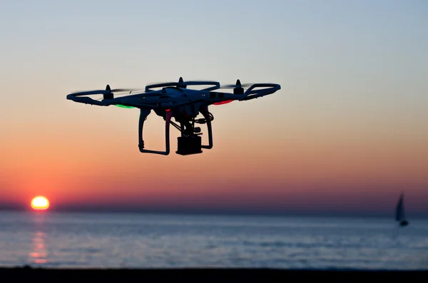 Drone volador con cámara en el cielo al atardecer — Foto de Stock