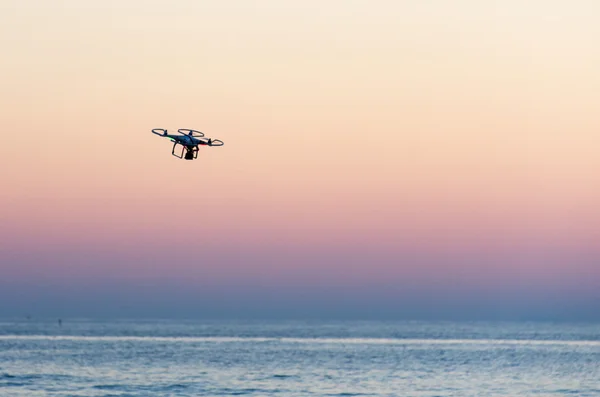 Drone volador con cámara en el cielo al atardecer — Foto de Stock