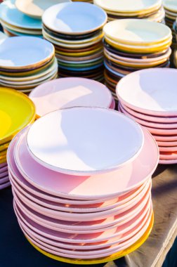 İtalya'da bir bit pazarında sıralanmış renkli porselen tabak yığını