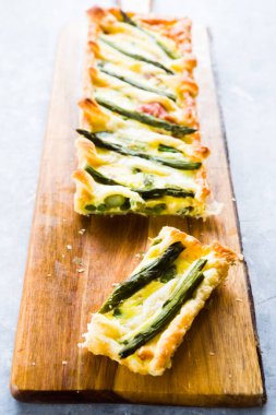 Adım adım yumurta sarısı, krema, parmesan, brisee makarna, benek ve kuşkonmazla yapılan kuşkonmazlı tart ve kuşkonmazın tarifi. Pişmiş ve servis edilmiş, üst görünüm, düz kompozisyon
