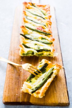 Adım adım yumurta sarısı, krema, parmesan, brisee makarna, benek ve kuşkonmazla yapılan kuşkonmazlı tart ve kuşkonmazın tarifi. Pişmiş ve servis edilmiş, üst görünüm, düz kompozisyon
