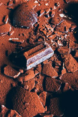 Çikolata parçaları. Gri soyut arka planda büyük bir çikolata çubuğu. Çikolata dilimleri, tatlı yemek fotoğraf konsepti, Lav keki yapmak için doğranmış çikolata..