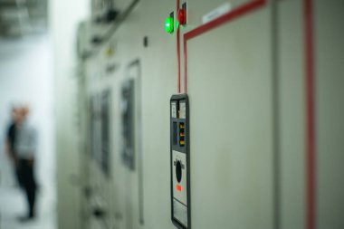 Arka planda bulanık elektrikçi ile elektrik odasındaki kontrol karabinasında yakın ışıklandırma göstergesi