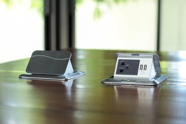 Ofisteki ahşap masanın yüzeyine monte edilmiş, yakın plan elektrik prizleri ev ofisindeki ahşap masanın üzerine kurulmuş.