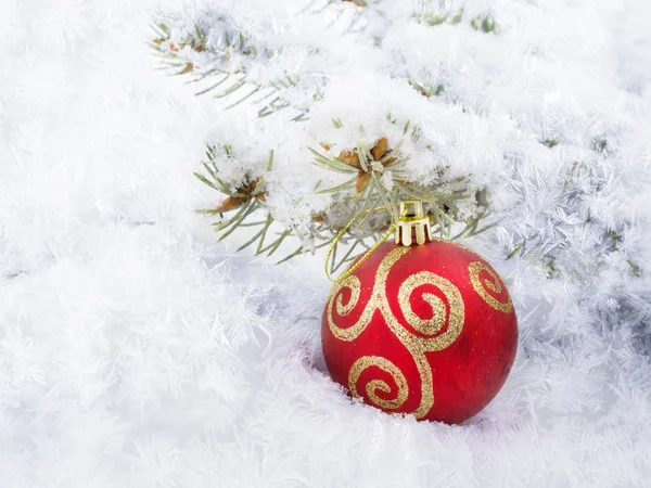 Bola roja de Navidad yacen en la nieve — Foto de Stock