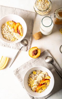 Hızlı kahvaltı manzarası. Sütlü granola, taze meyve ve tohum: şeftali, muz, chia tohumu.