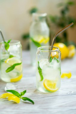 Naneli limonata ve şeffaf bardaklar içinde ahşap bir masada.