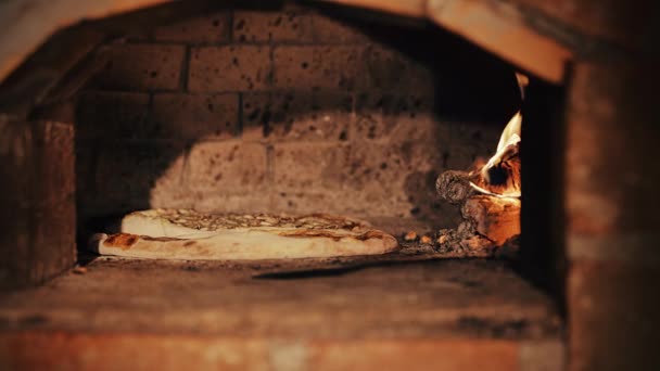 Выпечка пиццы в дровяной печи — стоковое видео