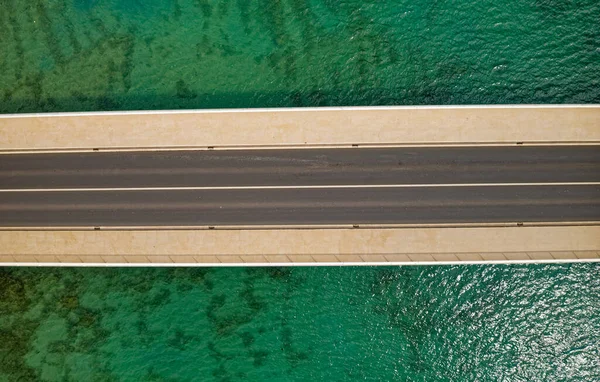 Aerial top view of a long bridge above a sea — Stock Photo, Image