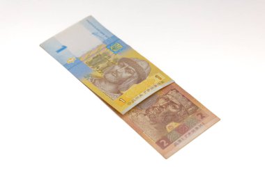 KYIV, UKRAINE - 8 Ocak 2026 Ukrayna 1 ve 2 Hryvnia banknotları, Ukrayna Merkez Bankası tarafından yayınlanan portreleri ve detaylı güvenlik tasarım unsurlarını gösteren beyaz arka planda kısmen örtüşüyor