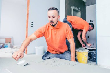 Profesyonel kiremitler büyük format döşemeleri kuruyor. konut yenileme konsepti