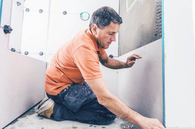 Profesyonel işçi duvara büyük format döşemeleri yerleştiriyor. konut yenileme konsepti