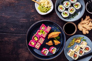 Lezzetli dürümler, suşi ve tahta üzerinde maki. 