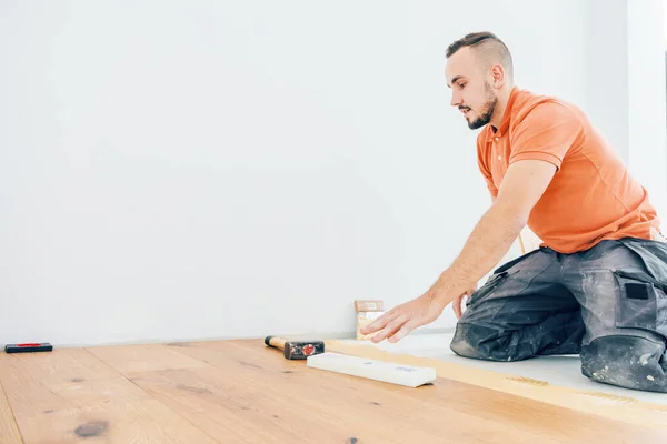 建設現場に寄木細工の床を設置する男性労働者 — ストック写真