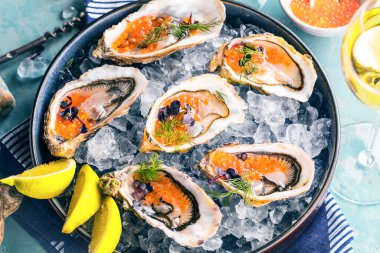 Lezzetli istiridye ve limon. Bitkilerle ve somon havyarlarıyla süslenmiş..