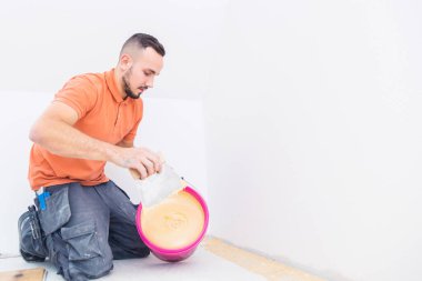 İnşaat alanında çalışan bir adam. Parke döşeme  