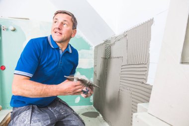 Erkek tilkiler duvara geniş format fayanslar kuruyor. konut yenileme konsepti