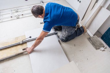 Erkek tiler ev yenileme sırasında geniş format fayanslar kuruyor 
