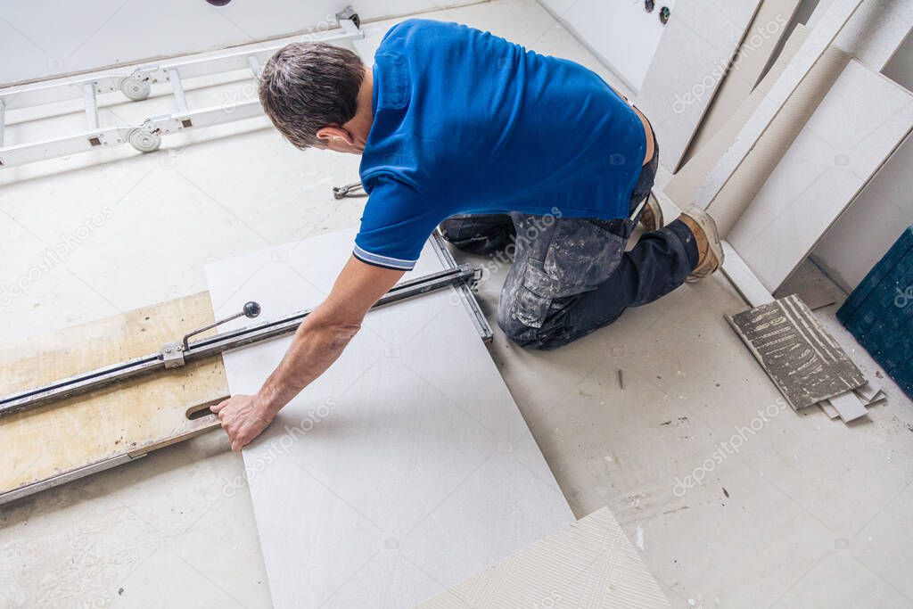 male tiler installing large format tiles during home renovation 