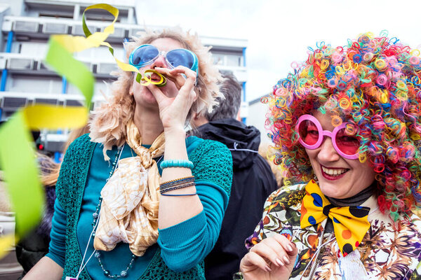 group of cheerful young friends celebrating carnival party outdoors