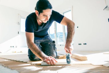 Ev tadilatı sırasında meşe parke döşeme işçisi