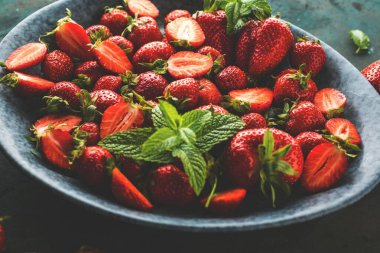 Yeşil nane yapraklı taze sulu çilekler. 