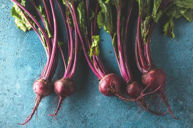 Mavi yüzeyde taze pişmemiş pancarların yakın plan görüntüsü