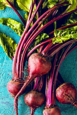 Mavi yüzeyde taze pişmemiş pancarların yakın plan görüntüsü