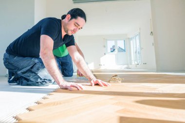 Erkek işçi ev geliştirme sırasında meşe parke döşeme