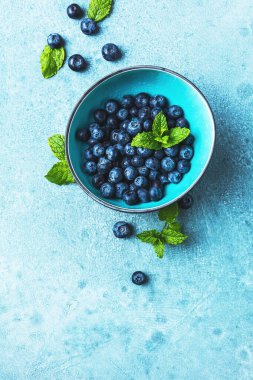 Mavi arka planda taze olgun yaban mersini kasesi