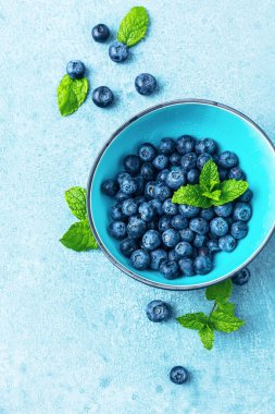 Mavi zemin üzerinde nane yapraklı taze yaban mersini.