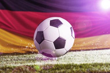 Alman bayrağı ve futbol topunun yeşil çimlerde yakın plan görüntüsü